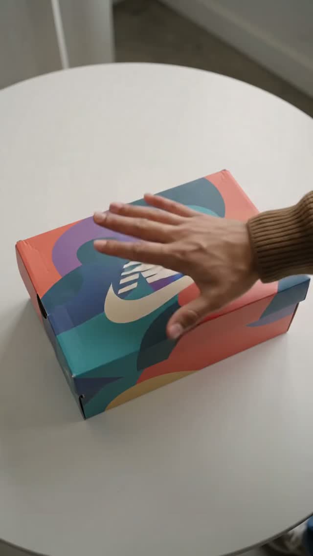 Generated opening frame showing a closed multicolored shoe box on a table